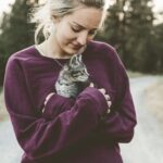 女性が猫を抱っこしている写真